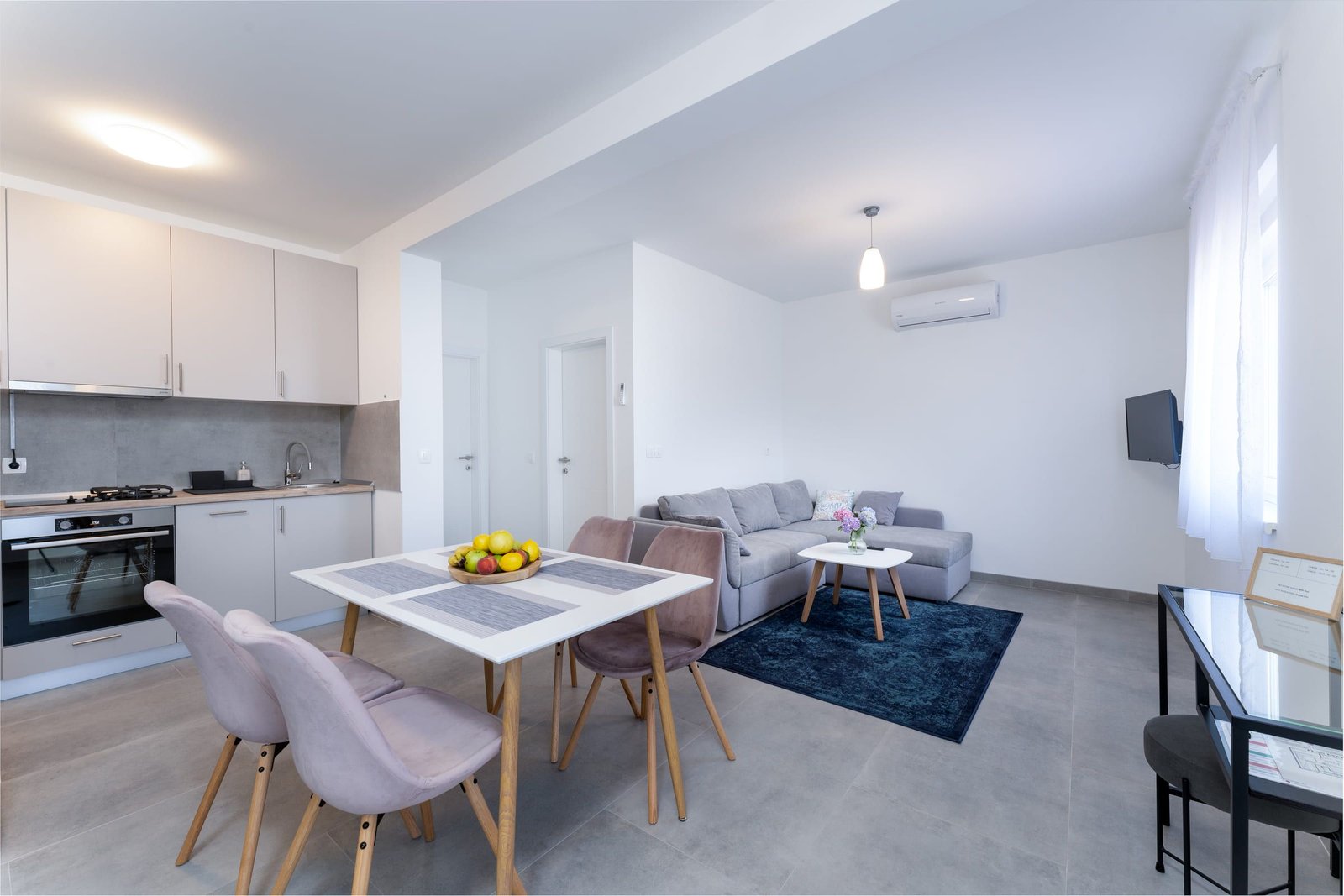 Living room with kitchen and dining area in the Sunrise apartment